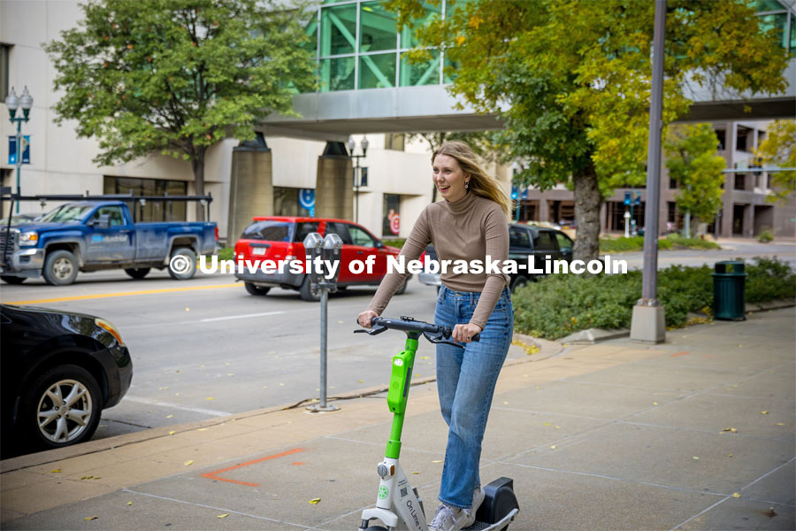 Emma Dostal rids a Lime e-scooter in downtown Lincoln. About Lincoln with the Lime Scooter e-Scooter program. October 18, 2023. Photo by Kristen Labadie / University Communication.
